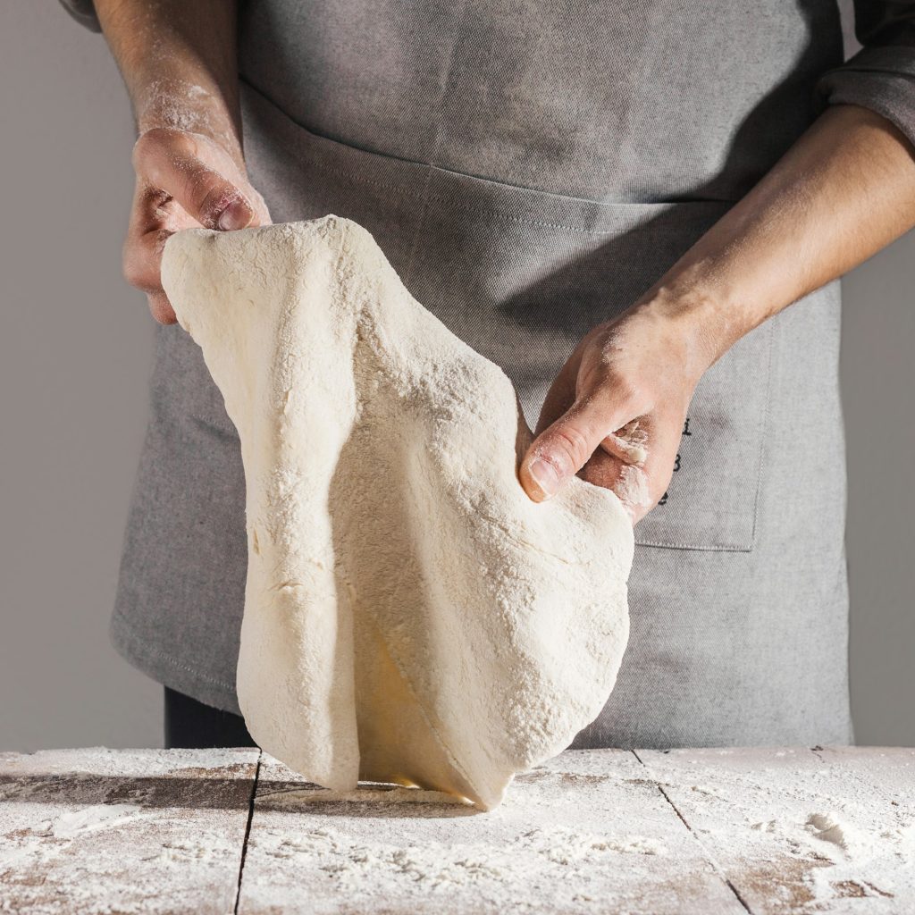 Chef haciendo y amasando masa fresca. Pizza Nonno. Nuestra Historia.